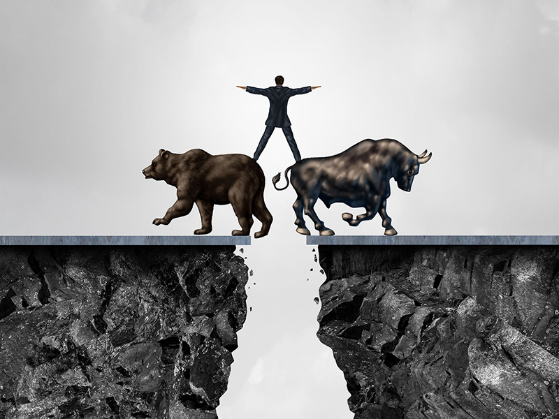 Homme d'affaires en équilibre debout sur un ours et un taureau, au-dessus d'un ravin.