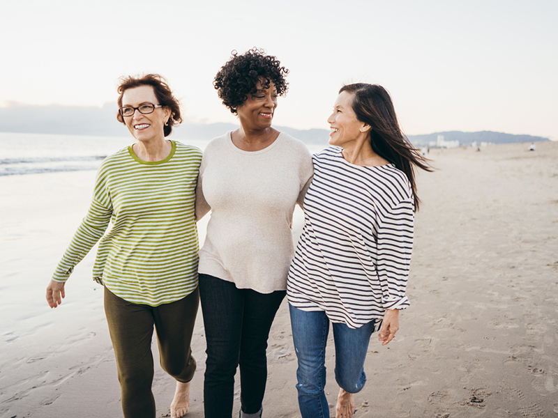 Trois femmes font une promenade sur la plage.