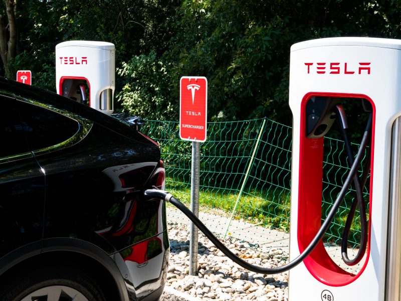 Une voiture électrique branchée à une borne Tesla.
