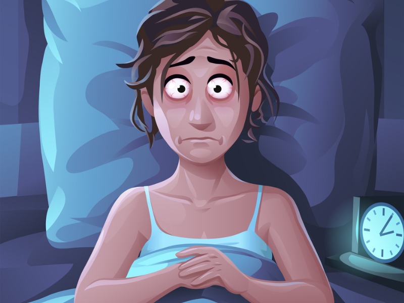 Une jeune femme dans un lit avec les yeux grands ouverts.
