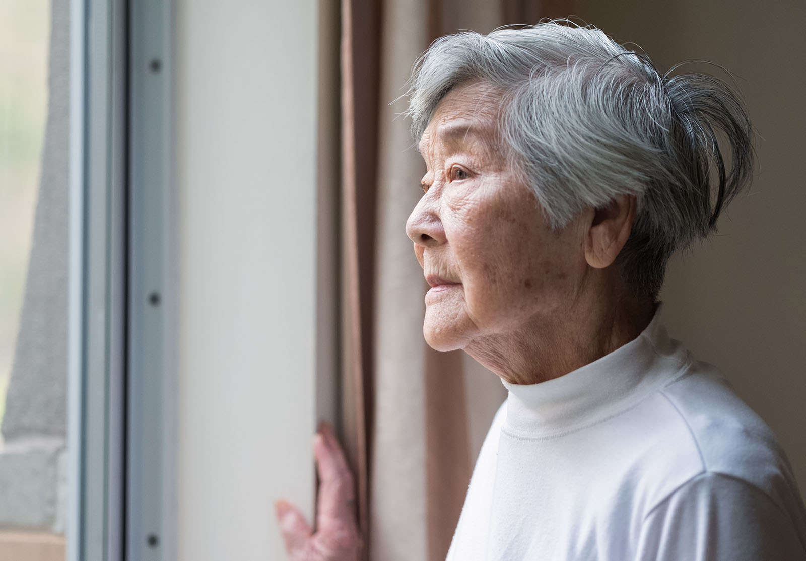 Femme âgée chinoise regardant à l'extérieur.